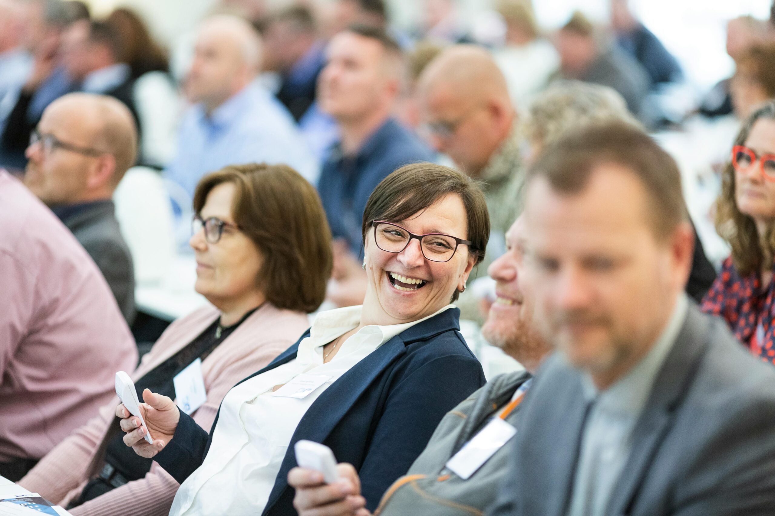 an audience of people and focused on a lady smiling